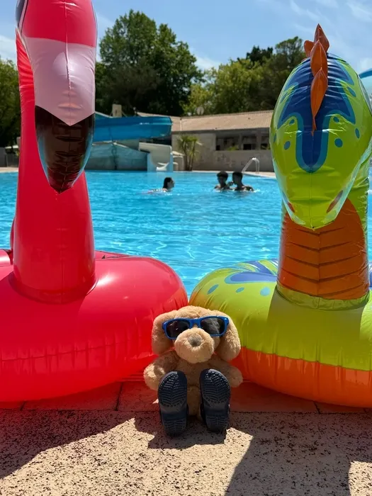 Deux boués avec la mascotte du camping se tenants devant le toboggan